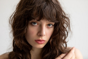Young brunette woman with a tousled wolf cut with a fringe